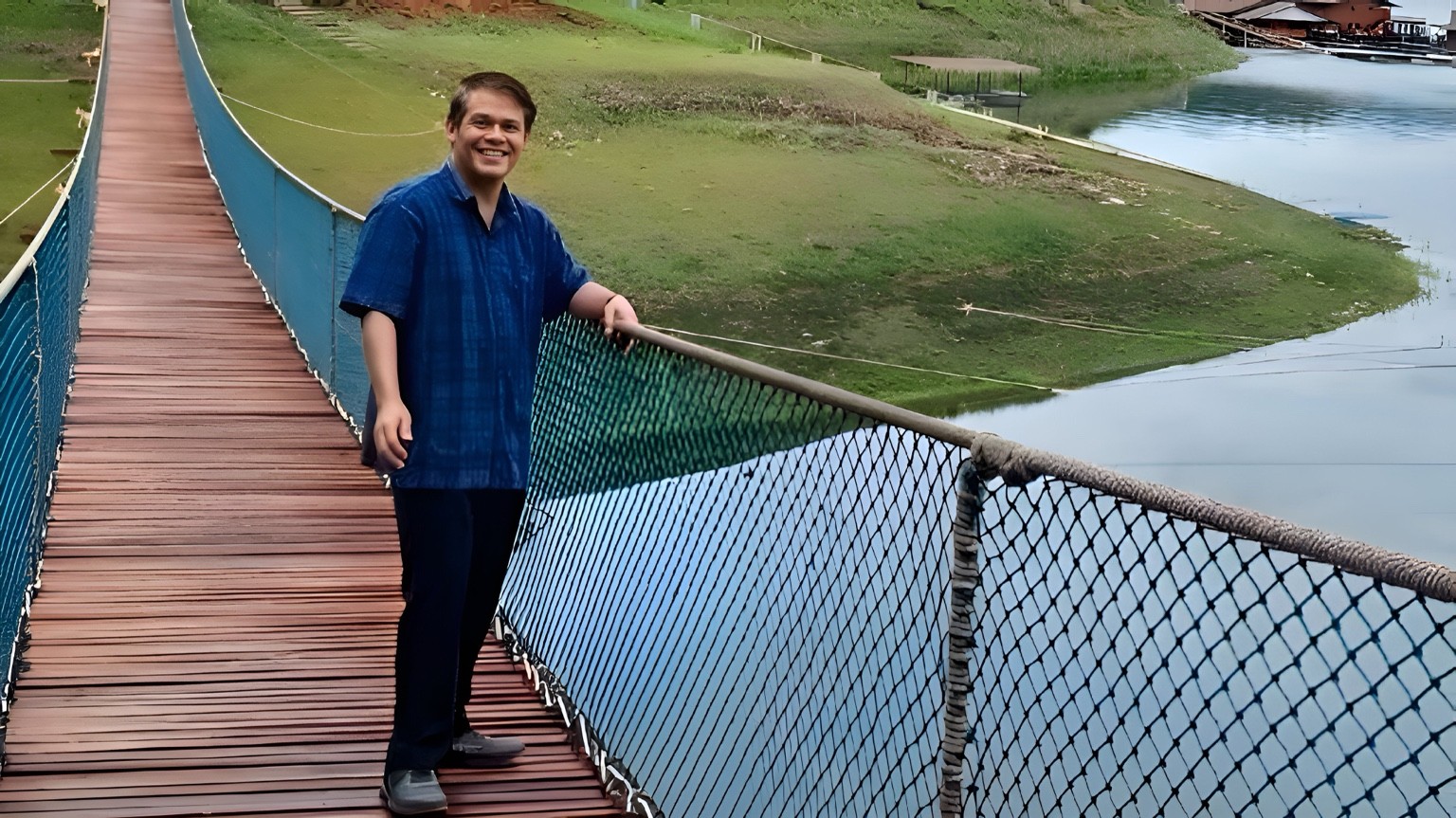 Dr. Supakorn Buasai standing on a suspension bridge